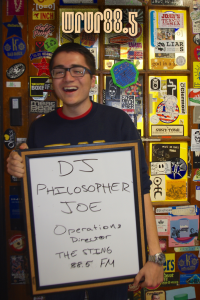 DJ Philosopher Joe (Operations Director, Sting and FM DJ) in front of the Sticker Door