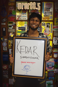 Kedar - General Manager - in front of the Sticker Door